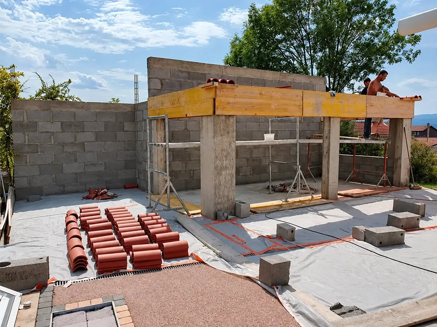 Chantier de gros œuvre : murs en blocs béton et palettes de tuiles près de Clermont-Ferrand
