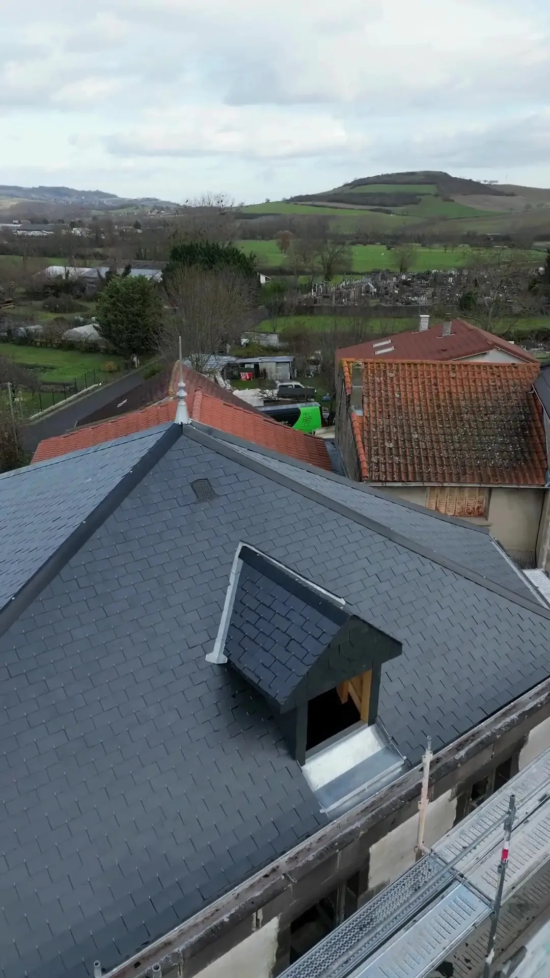 Vue de drone d’une toiture en ardoise avec lucarne, pendant un diagnostic de toiture