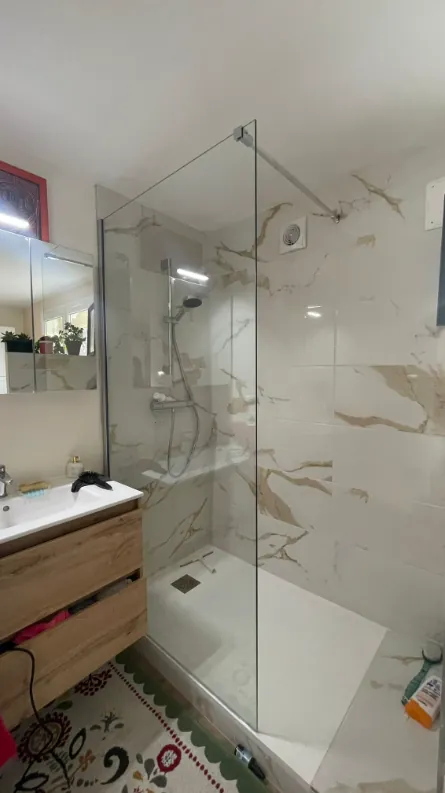 Douche carrelée avec paroi vitrée et meuble vasque